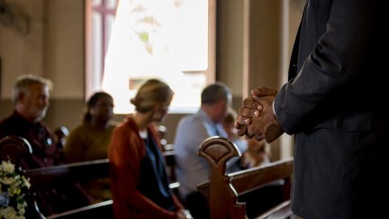 Church-goers sit in pews.