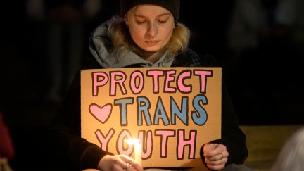 A person at a Brianna Ghey vigil holding a sign that reads, 