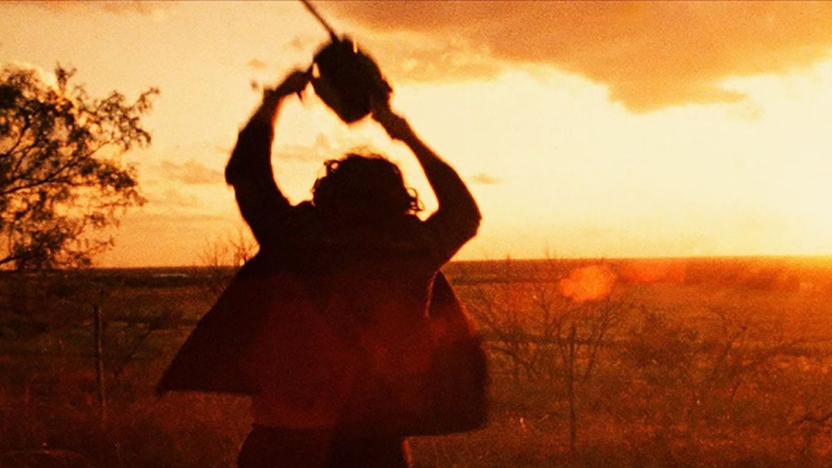 Leatherface swinging his chainsaw during sunrise in The Texas Chain Saw Massacre.